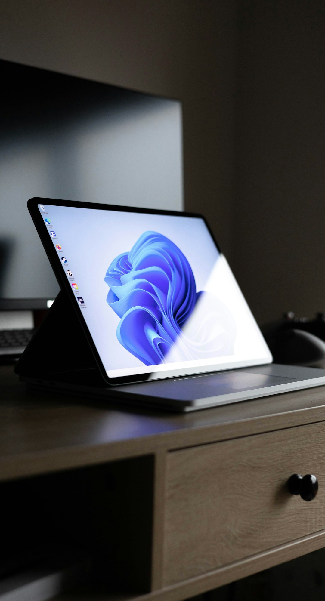 Open notebook with handwritten notes next to a laptop and pen on a wooden desk
